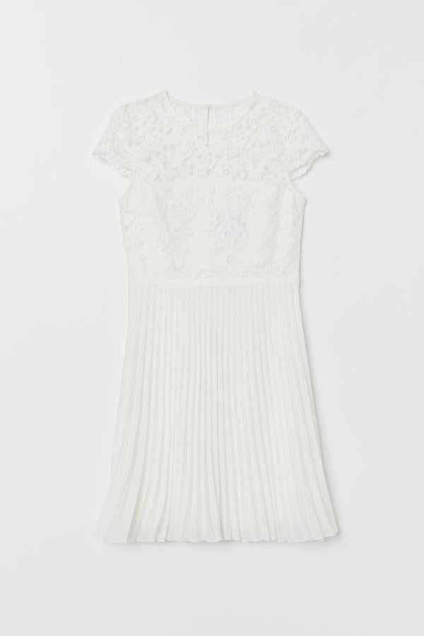 Una boda de día sencilla, una novia con zapato plano y este vestido mini con cuerpo de encaje y falda plisada de H&M (59.99 euros).