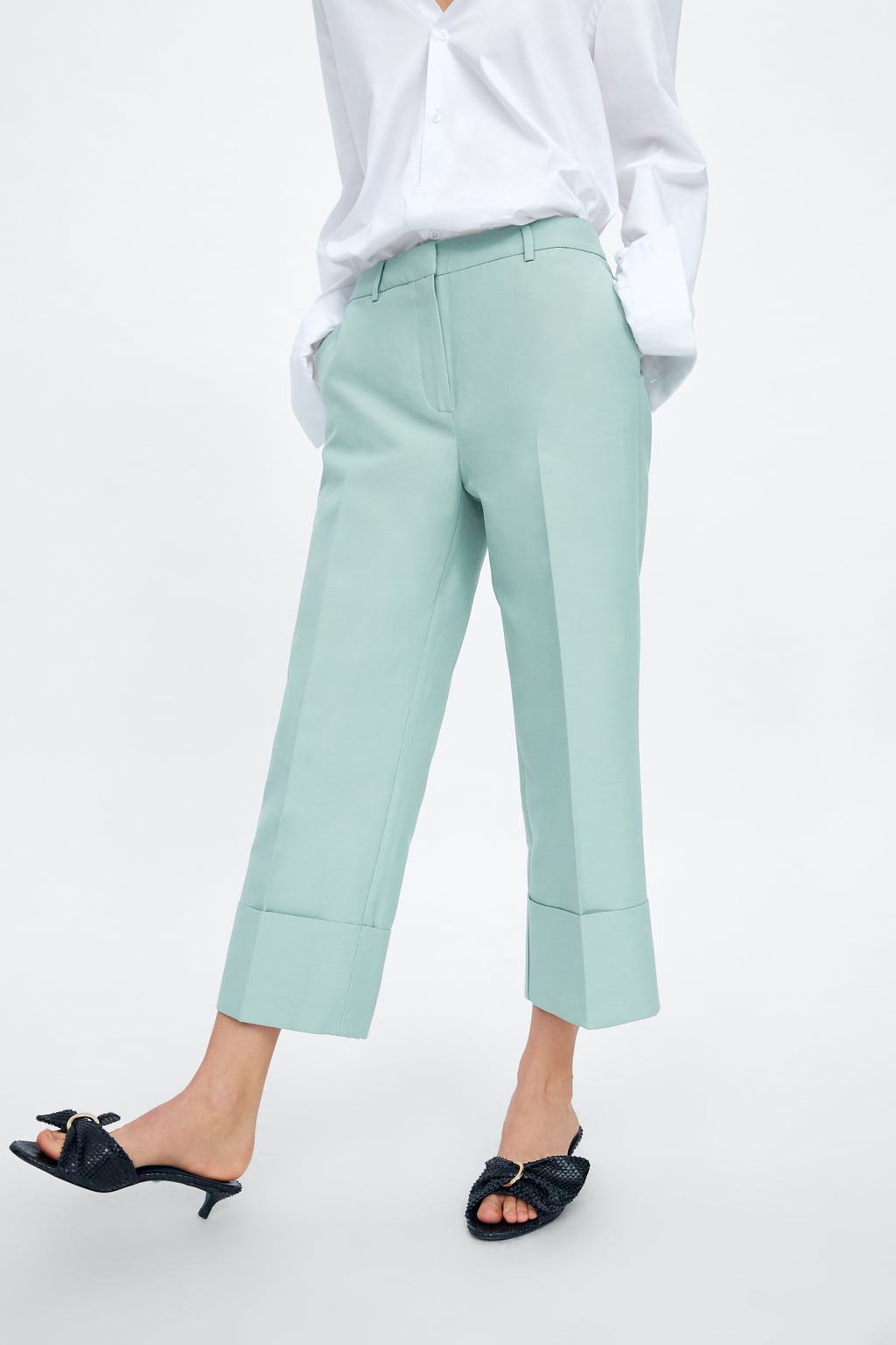 El truco de estos pantalones verde agua de Zara para que queden perfectos con sandalias planas, está en el bajo con una vuelta doble. Esto hace que la pierna se alargue visualmente y ganes unos centímetros de altura. (39,95 euros).