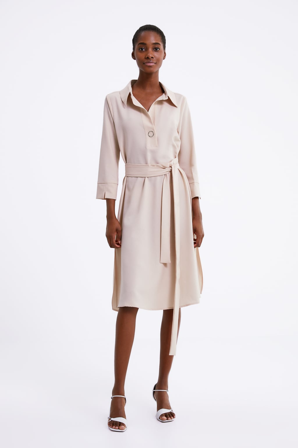 Vestido fluido de cuello solapa con escote pico y manga larga. Detalle de cinturón. 19,99 euros en Zara.