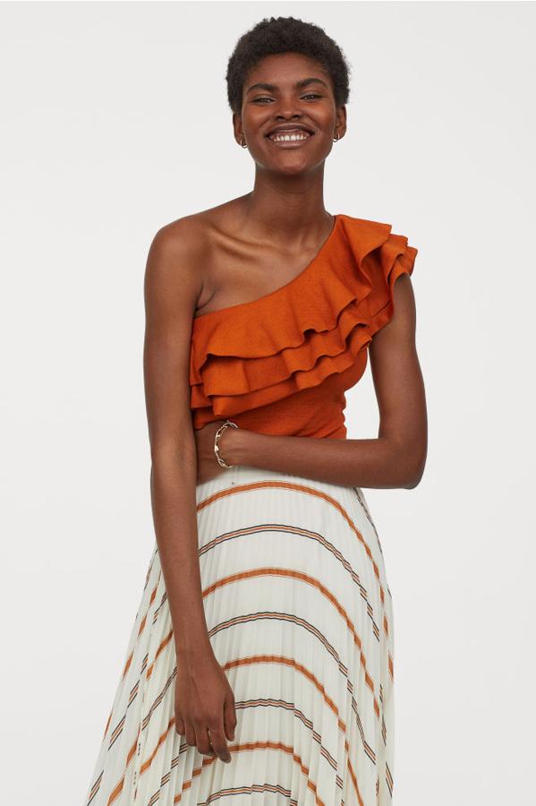 Body con escote asimétrico y detalle de volante en color naranja, 29,99 euros.