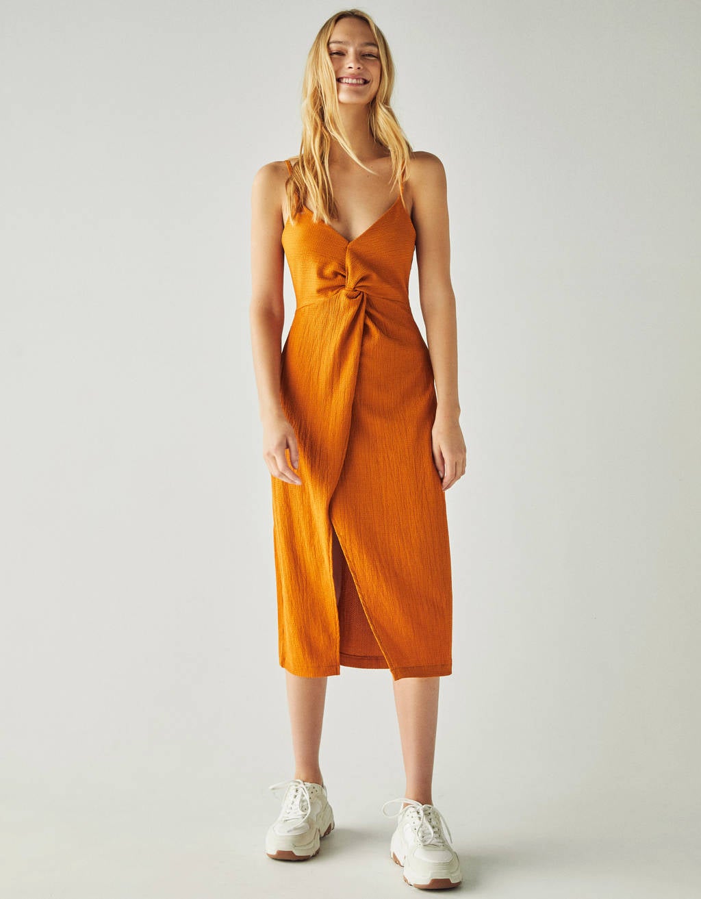 Las tonalidades del amarillo son infinitas y eso es justo con lo que debes jugar si no te atreves con el más vivo de toda la gama. Esta opción de Bershka en tono mostaza queda súper elegante y hace tipazo gracias al nudo que se ciñe en la cintura. (19,99 euros).