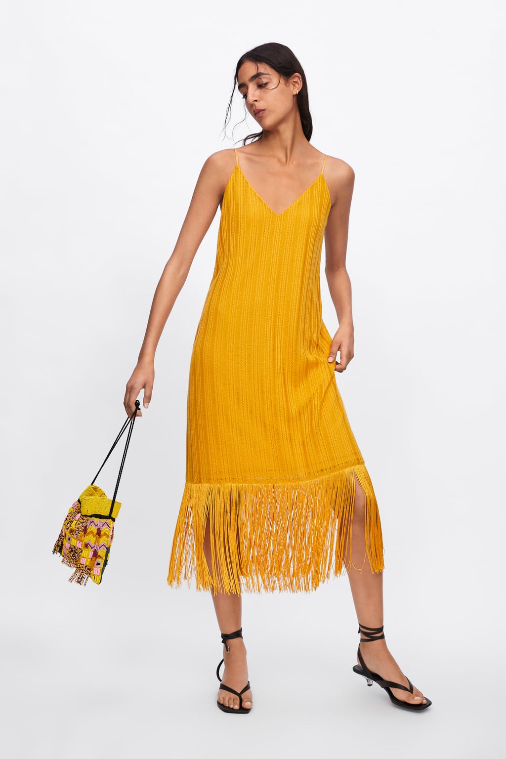 Sal de lo clásico y apuesta por los flecos con este vestido de Zara de punto en tono mostaza. (25,95 euros).