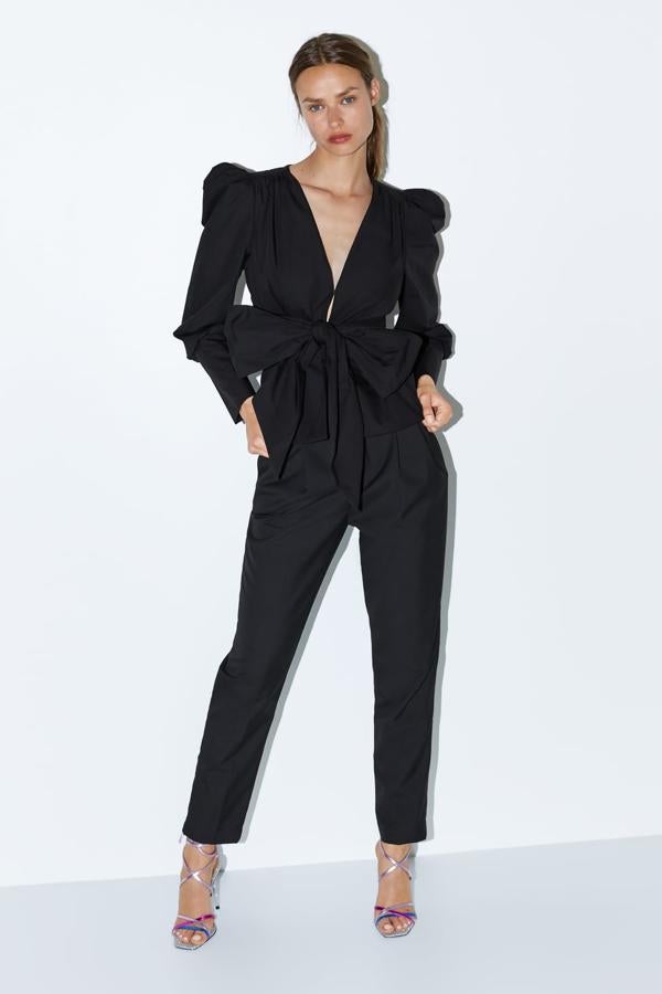 Chaqueta con escote pico y manga abullonada. Lleva la aplicación de un lazo del mismo tejido y cierra en el frontal con un gancho metálico (49,95 euros).