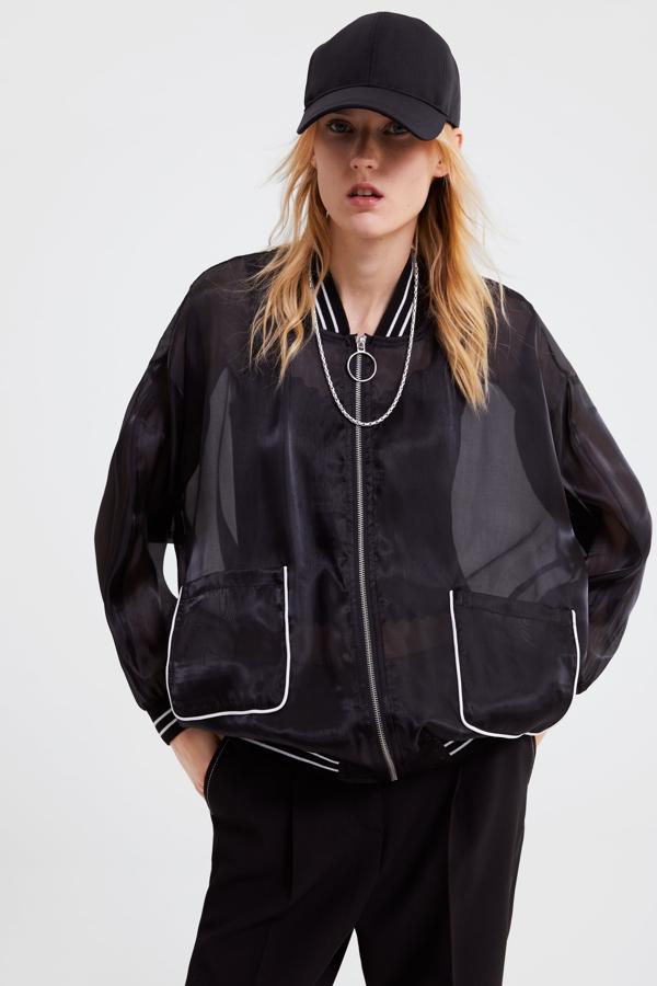 Para las que quieran un look 'sporty chic', nos quedamos con esta cazadora tipo bómber en organza negra con ribetes blancos en contraste.  Precio: 29.95 euros  en  Zara .
