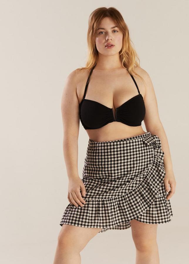 Minifalda con diseño acampanado y cruzadoy estampado de cuadros vichy. Cierre con un lazo y añade un detalle de volantes (Mango, 39,99 euros). El sujetador de biquini es de tejido elástico y lleva tirantes desmontables y ajustables (Mango, 29,99 euros).