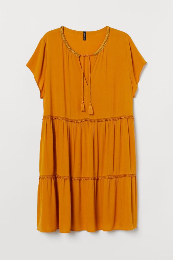 Vestido en tejido vaporoso de crepé de viscosa con detalles de encaje. Lleva mangas japonesas, escote de pico con cordones y costura en la cintura y en la falda. Va sin forrar (H&M, 29,99 euros).