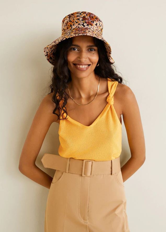 Este original top amarillo con detalle de nudos en los tirantes es uno de nuestros favoritos. Es de Mango y cuesta 12.99 euros.
