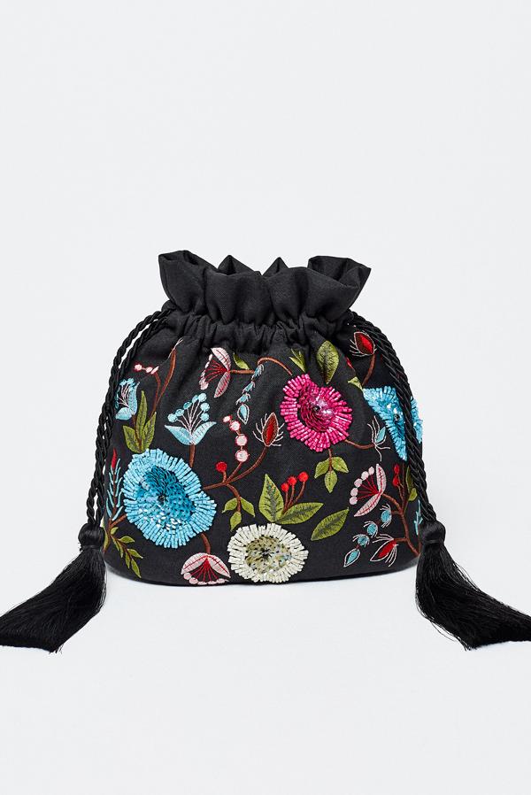 En negro, con flores de colores que nos recuerdan a un mantón español, este modelo es de Sfera. Y aunque en la foto no se aprecie, tiene un asa larga para llevarlo colgado del hombro (15,99 euros).