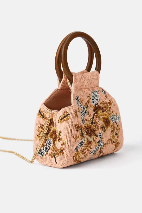 El más romántico de todos está en Zara y este con asas de madera y abalorios que forman flores (29,95 euros). Te quedará ideal con un vestido blanco calado.