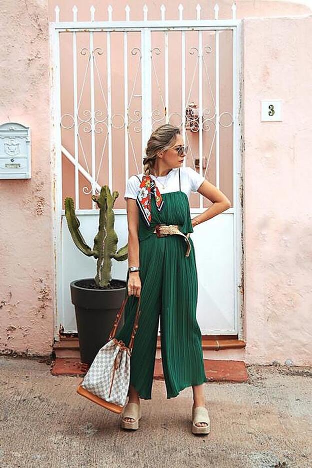 La influencer Priscila Betancort lleva el famoso mono verde plisado de Zara con una camiseta blanca debajo y un cinturón de rafia.