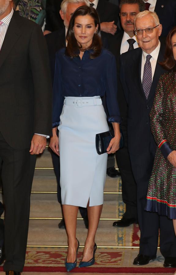 Para presidir en Madrid, junto al Rey Felipe VI, el Pleno de la Real Academia Española, doña Letizia combinó una blusa de satén azul noche de Felipe Varela que guarda en su armario desde hace varias temporadas con una nueva falda lápiz en azul bebé con cinturón incorporado de Hugo Boss. Como complementos, clutch y salones, también reciclados, de Magrit.