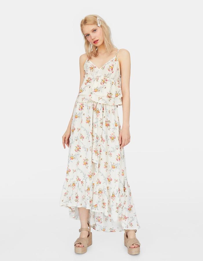 Un estampado de flores híper romántico es el protagonista absoluto de esta falda, terminada en un volante y con un lazo en el mismo tejido a la cintura elástica (Stradivarius, 25,99 euros).