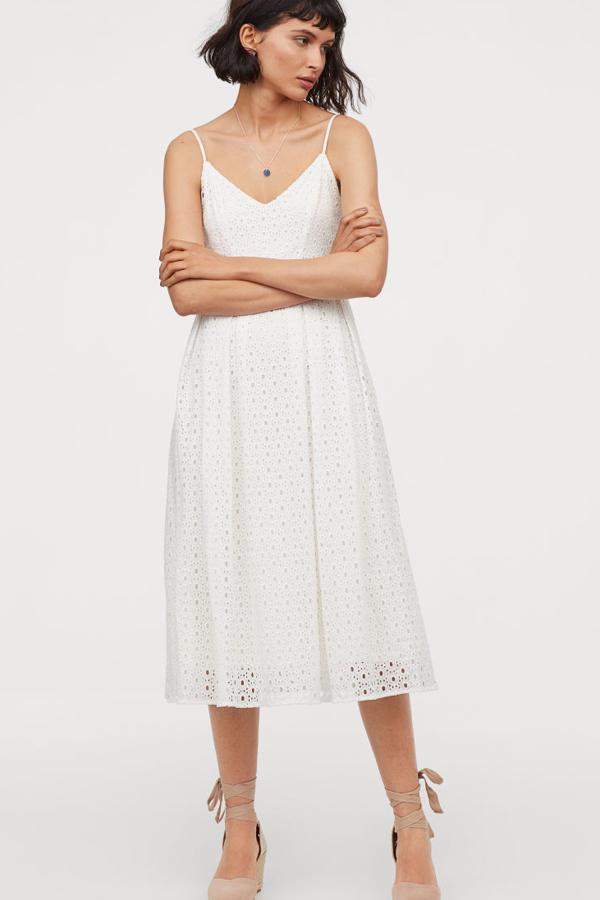 Vestido con bordado inglés en todo el tejido, escote de pico y tirantes espagueti ajustables. Lleva una falda con ligero vuelo hasta la rodilla y va todo forrado (H&M, 79,99 euros).