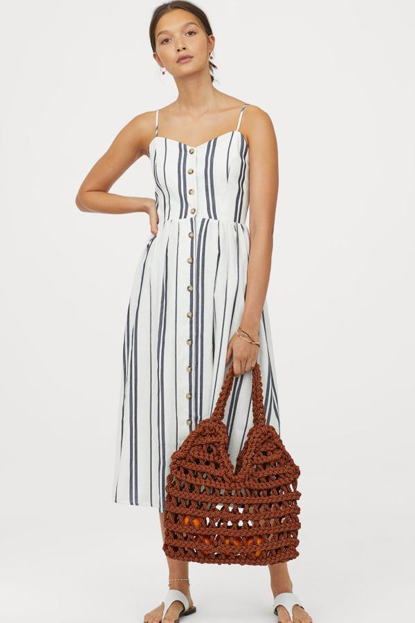 Vestido de tela con tirantes finos ajustables, ligero escote de pico y botones. Lleva un fruncido en la espalda, costura en la cintura y falda con vuelo. El cuerpo va forrado (29,99 euros).