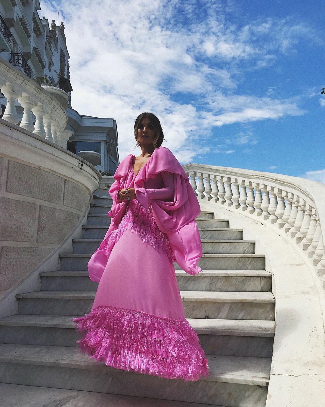 Ángela Rozas, más conocida en Instagram como Madame de Rosa, se ha decantado por un diseño combinado en color rosa donde encontramos plumas, mangas abombadas y un escotazo en V que nos ha encantado. Está firmado por Teté by Odette. El peinado, que no se aprecia en la imagen, se basa en un semirecogido donde se alterna una trenza de espigas. Las horquillas plateadas en forma de estrellas le dan un toque de "fantasía".