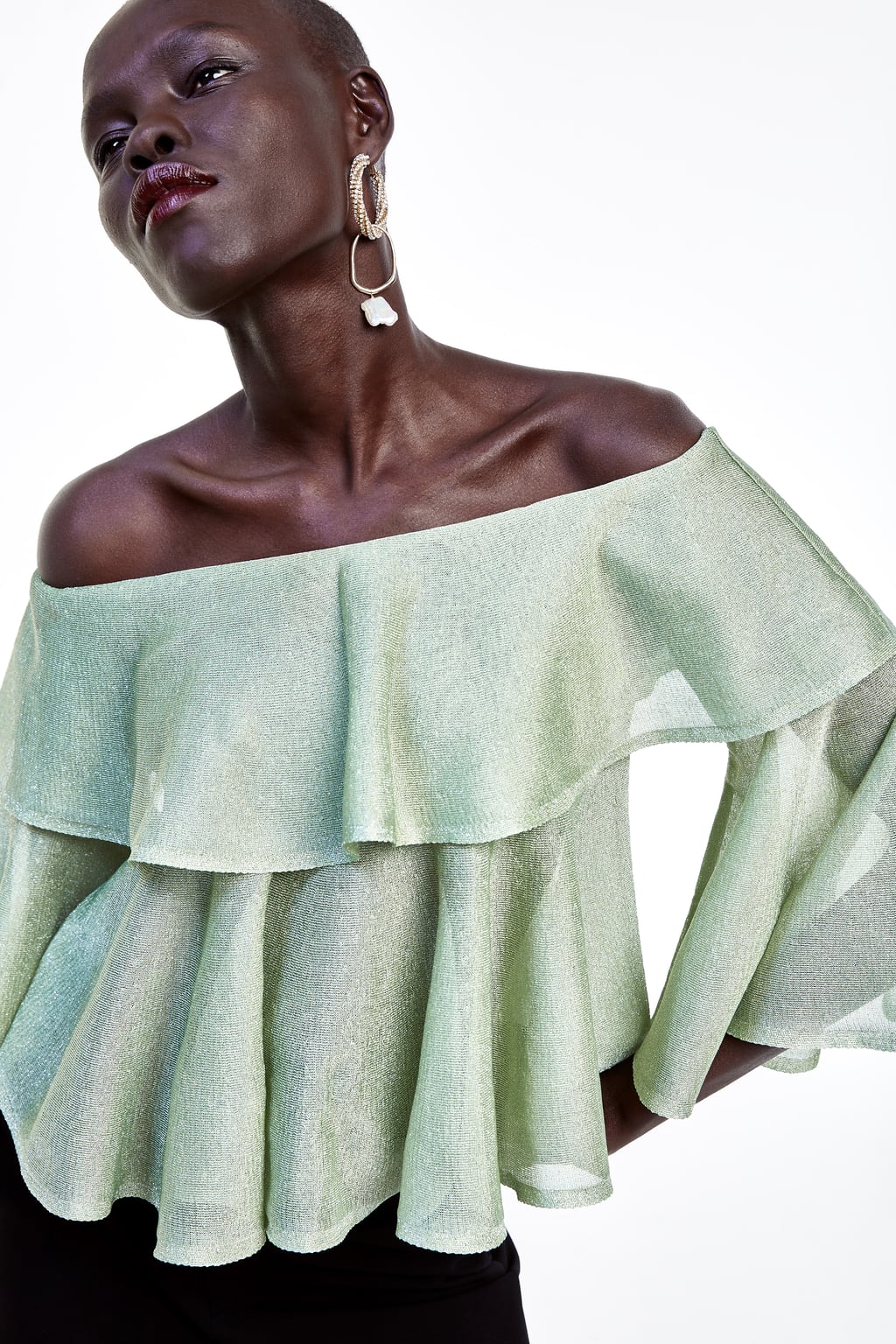 Top con hombros descubiertos, volantes y tejido de hilo metalizado: 25,95 euros en Zara.