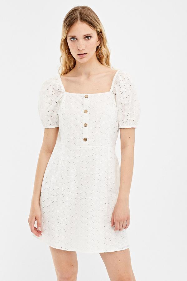 Los vestidos blancos caados son otro must veraniego y visten más que ninguno. Este con corte tubo y manga con volumen costaba 29,99 y se ha quedado en 19,99 euros en las rebajas de Springfield.