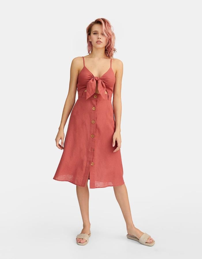 Los colores tierra son otra de las tendencias de la primavera y el verano. Este vestido con botones en color teja nos ha parecido muy original con el nudo en el escote y súper ponible. Lo han rebajado a 15,99 euros.