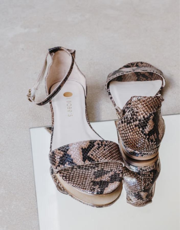 Sandalias con tira cruzada, pulsera tobillera y estampado de serpiente, modelo Atenea Snake, 99 euros.