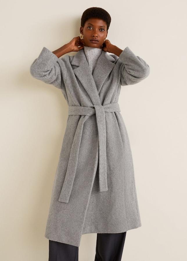Abrigo de lana desestructurado y largo con cuello clásico y cinturón desmontable a la cintura. Lleva bolsillos de parche (Mango, 59,99 euros).