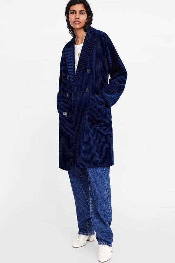 Abrigo cruzado de pana azul marino, con bolsillos delanteros de plastrón, bajo con abertura en espalda y botones combinados a contraste (Zara, 39,99 euros).