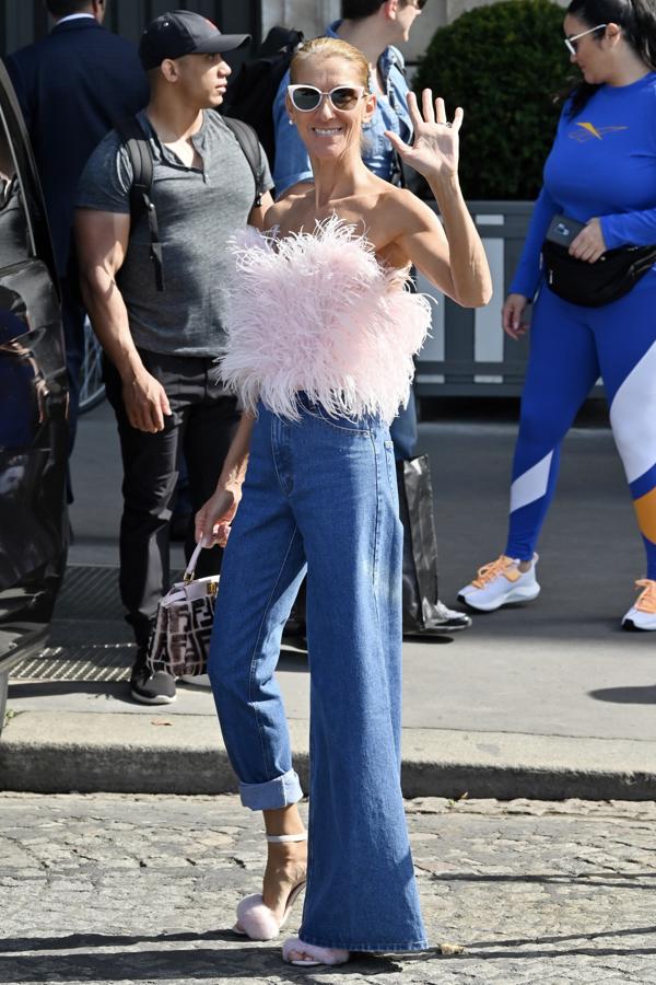 Las plumas son una de sus debilidades. Este look con top de Attico, sandalias de peluche y vaqueros acampanados nos ha encantado, pero no entendemos muy bien el bajo remangado en una de las perneras del pantalón. Cosas de celebrity.
