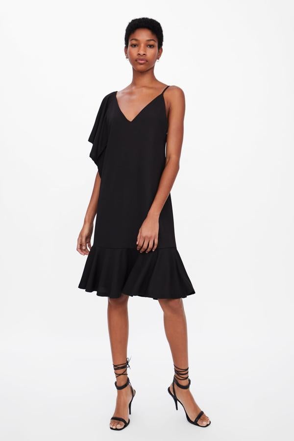 Vestido de Zara negro con manga asimétrica y volante en el bajo por 15,99 euros.