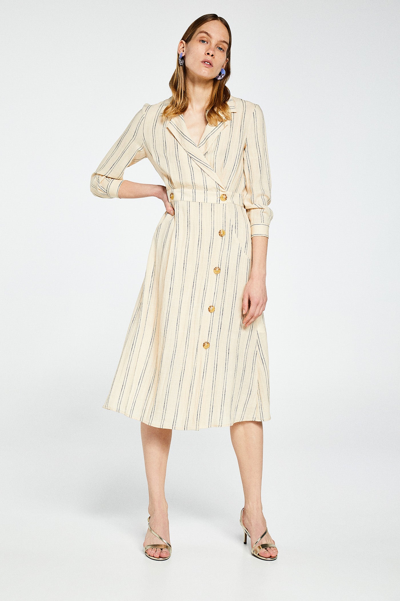 Vestido de lino cruzado con rayas diplomáticas. Elegante y acertada para los días de oficina. (29,99 euros)