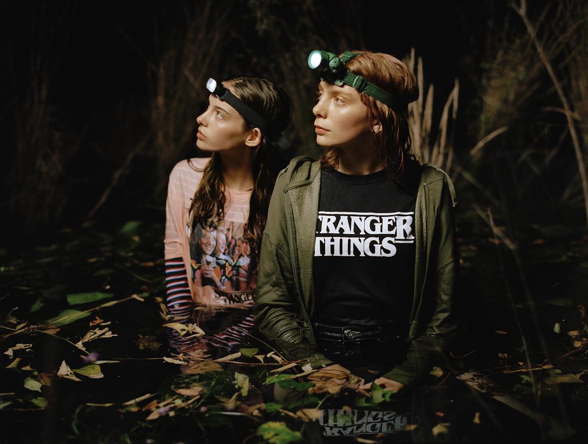 Camiseta de 'Stranger Things' en rosa palo con foto de Eleven y Max en el pecho y camiseta negra con logo de la serie en el centro (15,99 euros).