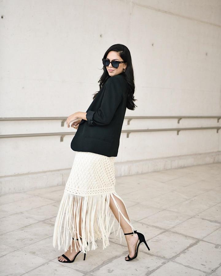 La influencer visitó el Cibelespacio de la MBFW con este look compuesto por un vestido de flecos en al bajo y una americana y sandalias negras.