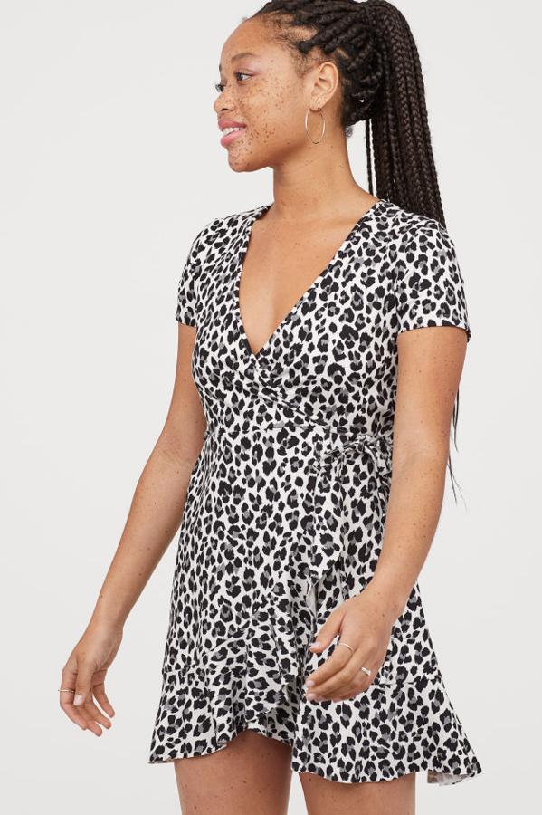 Vestido corto de punto con frente cruzado gracias a una lazada en el lateral. Lleva las mangas cortas y un ribete de volante en el bajo. El precio es imbatible: en H&M, 14,99 euros.