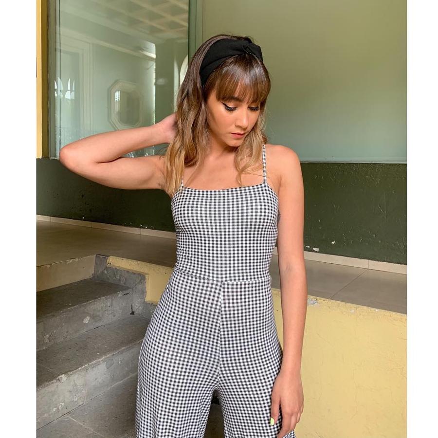 La cantante también apuesta por looks románticos. Este es con un mono con uno de los estampados de este verano: los cuadros vichy. ¿Otro punto de tendencia? La diadema.