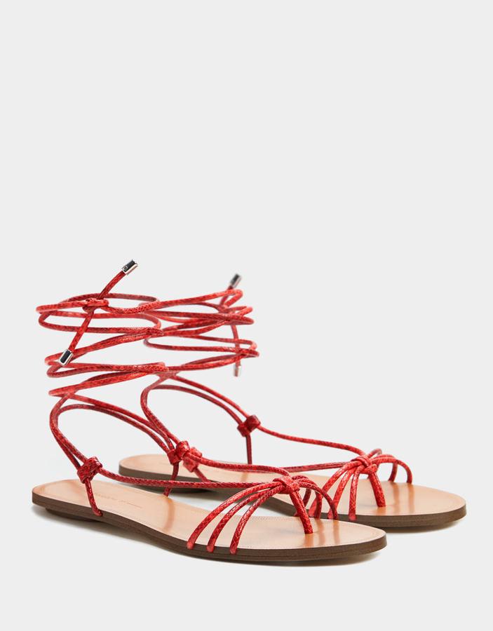 Sandalia en color coral y atada con tiras tubulares cruzadas que se atan a la pierna. Lleva un detalle de tiradores metálicos (Bershka, 19,99 euros).
