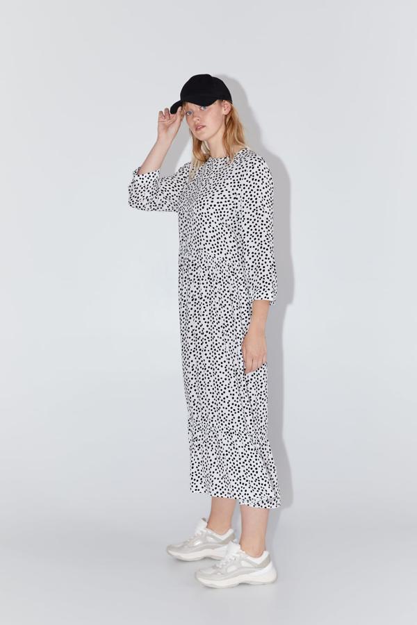 Vestido fluido de cuello redondo y manga por debajo del codo, con el bajo acabado con volante. Cierra en la espalda con abertura y botón (Zara, 39,95 euros).