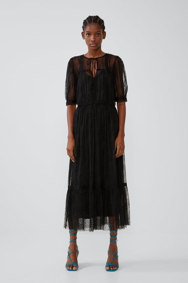 Vestido de escote pico con lazada y manga corta. Lleva la cintura elástica y el bajo acabado en un volante. Va forrado (Zara, 39,95 euros).