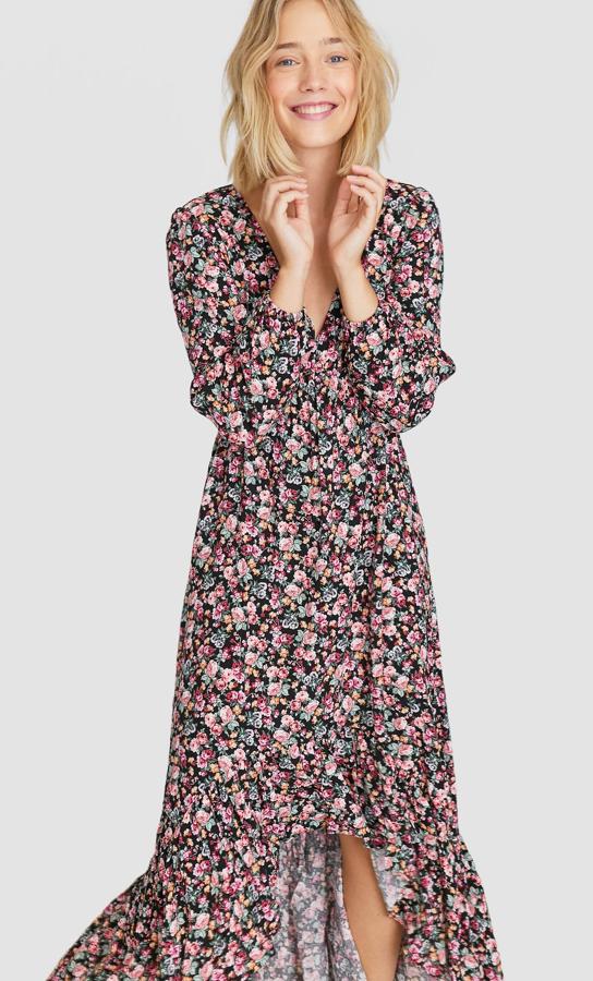 Precioso vestido largo con escote de pico y bajo asimétrico, adornado con un gran volante. Lo tienes en Stradivarius por 25,99 euros.