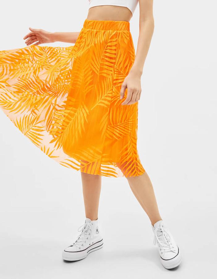 Falda midi plisada en color naranja neón con estampado tropical, 9,99 euros.