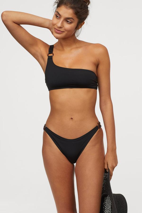 Bikini de H&M con el top asimétrico de un solo hombro que tan bien le funciona a Paula Echevarría. La braguita lleva anillas decorativas en los laterales (12,99 euros) y el top tiene relleno extraíble (17,99 euros). Ambos van forrados.