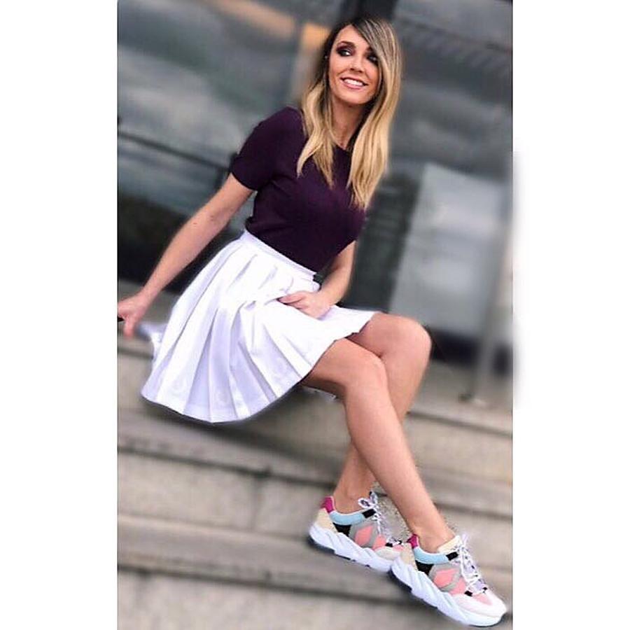 Las zapatillas coloridas de Mikaku protagonizaban este look de Anna Simon compuesto por una falda de tabas blanca y una camiseta burdeos.