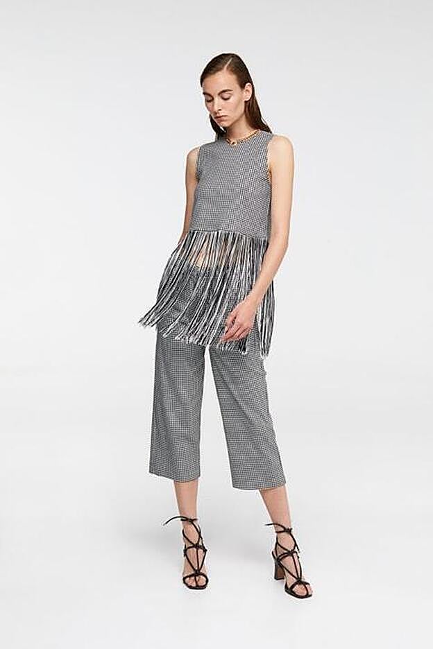 Cuenta con detalle de flecos en todo el bajo y estampado de cuadros.