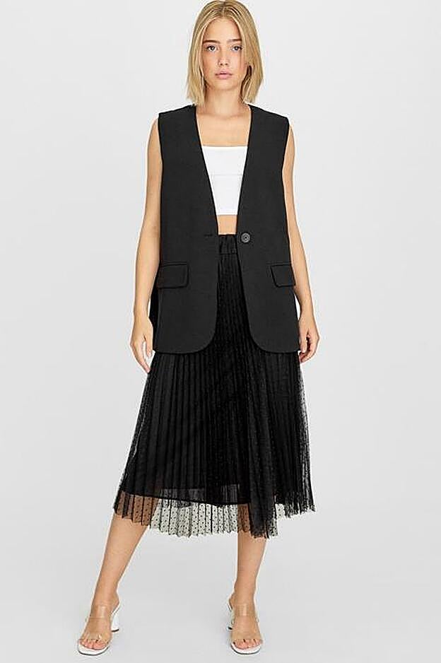 Falda plisada plumeti en tono negro. (19,99 euros).