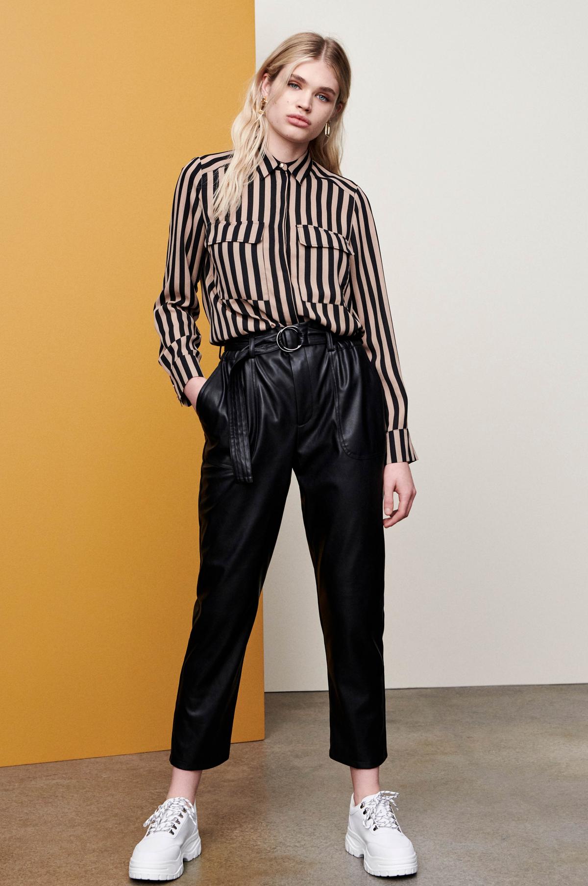 Camisa a rayas: 13 euros. Pantalón de polipiel: 19 euros. Zapatillas deportivas: 16 euros. Todo de Primark