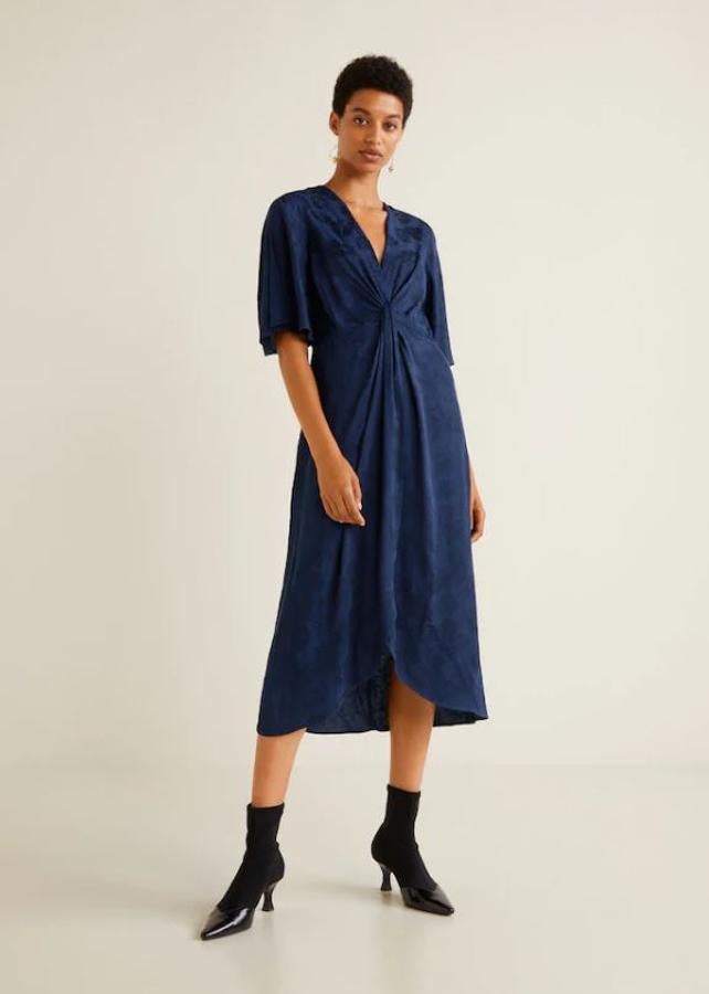 Azul oscuro, con un nudo en la parte del pecho y de manga hasta el codo, es una opción perfecta para una boda de día. Un tocado y... ¡lista!