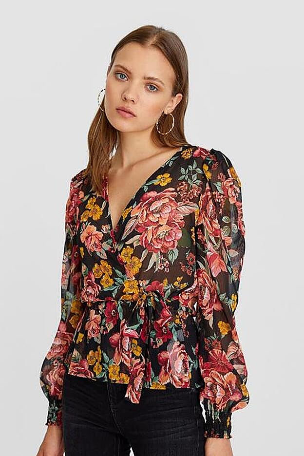 Incluye mangas abullonadas, diseño cruzado y lazada en la parte frontal.