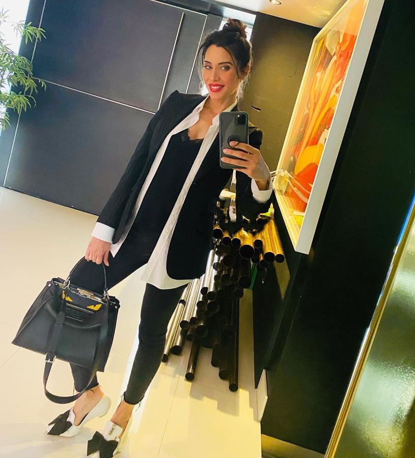 En blanco y negro y con americana. No es muy habitual verla vestida así de sobria pero ella siempre pone su toque a todos su estilismos. En este caso, con una sencilla camisa blanca y una americana de raya diplómatica, un look al que le ha dado un twist con la camisa desabrochada (que deja ver un top lencero) y unos zapatos con un gran lazo.