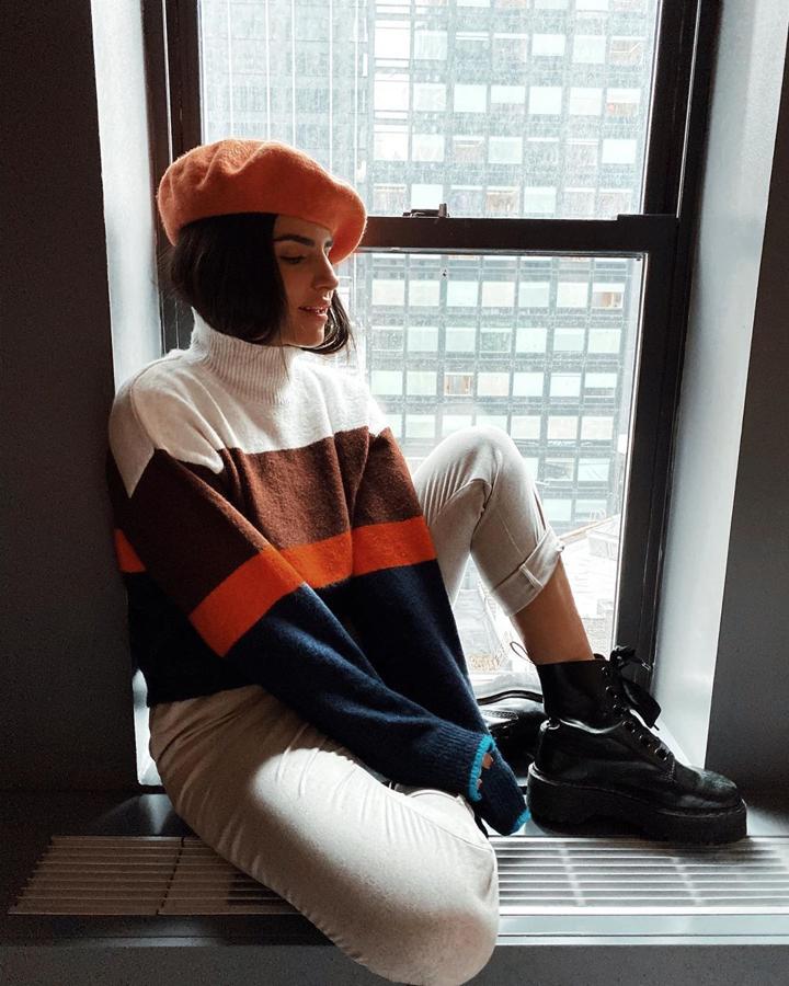 Marta Soriano con un  total look de H&M  formado por un jersey block de colores, pantalones beiege y boina naranja.