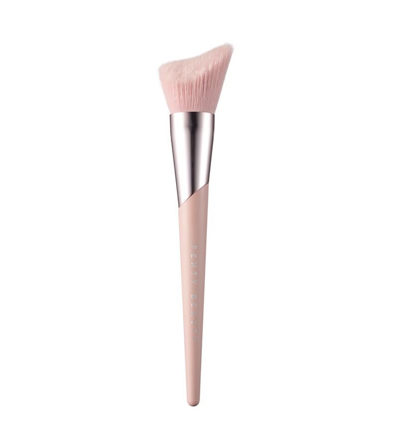 De cerdas sintéticas supersuaves, su corte asimétrico está inspirado en un diente de tiburón. Su forma proporciona la cantidad justa de polvos bronceadores.  Cheek-Hugging Bronzer Brush 190 de Fenty Beauty  (36 €).