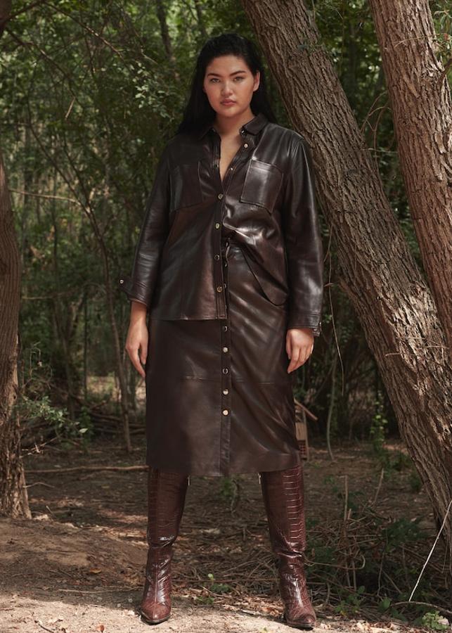 Falda midi y acampanada de piel color chocolate (89,99 euros), a juego con una cazadora de piel del mismo tono, con botones a presión en la parte delantera y bolsillos de parcha (99,99 euros). Todo de Violeta.