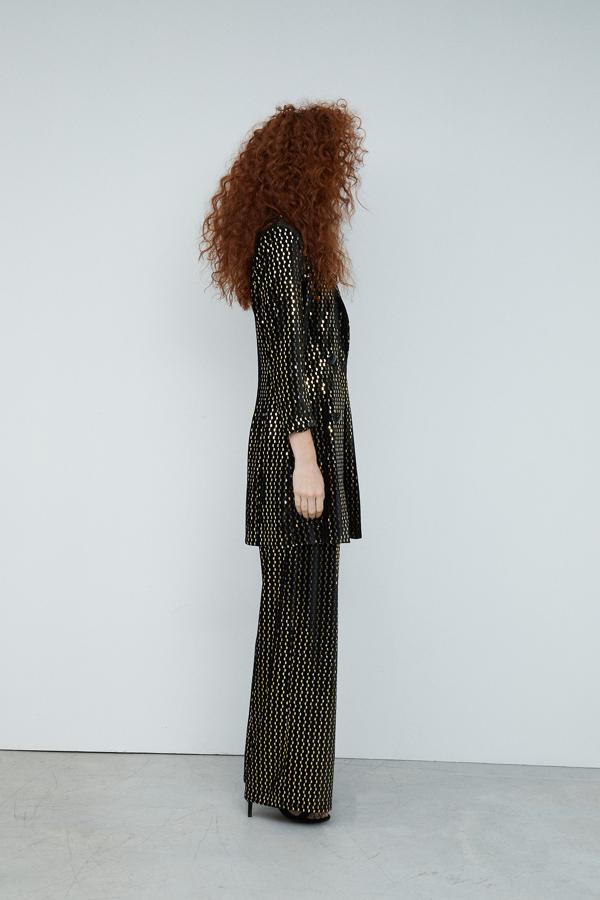 Traje negro de lentejuelas doradas con pantalón palazzo (15,99 euros) y americana de Sfera.