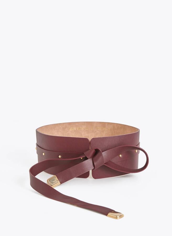 Cinturón confeccionado en piel de alta calidad de Uterqüe (69 euros). Es un diseño fajín con tachas en tonalidad dorada. Cierre mediante lazada.